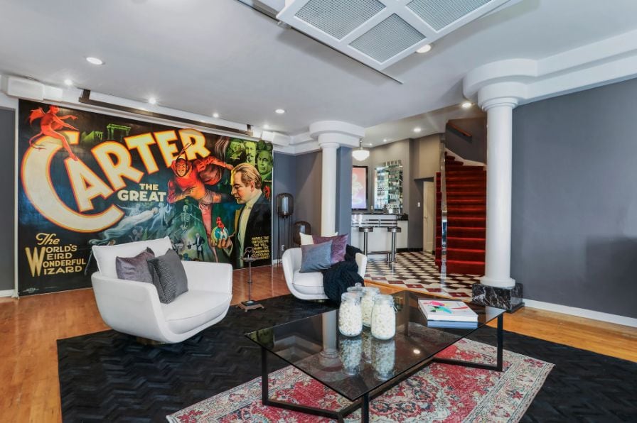 La sala tiene seis asientos de teatro de terciopelo rojo, un óculo de vidriera de colores, una chimenea, un enorme cartel de “Carter el Grande” (Foto: Charmaine David)