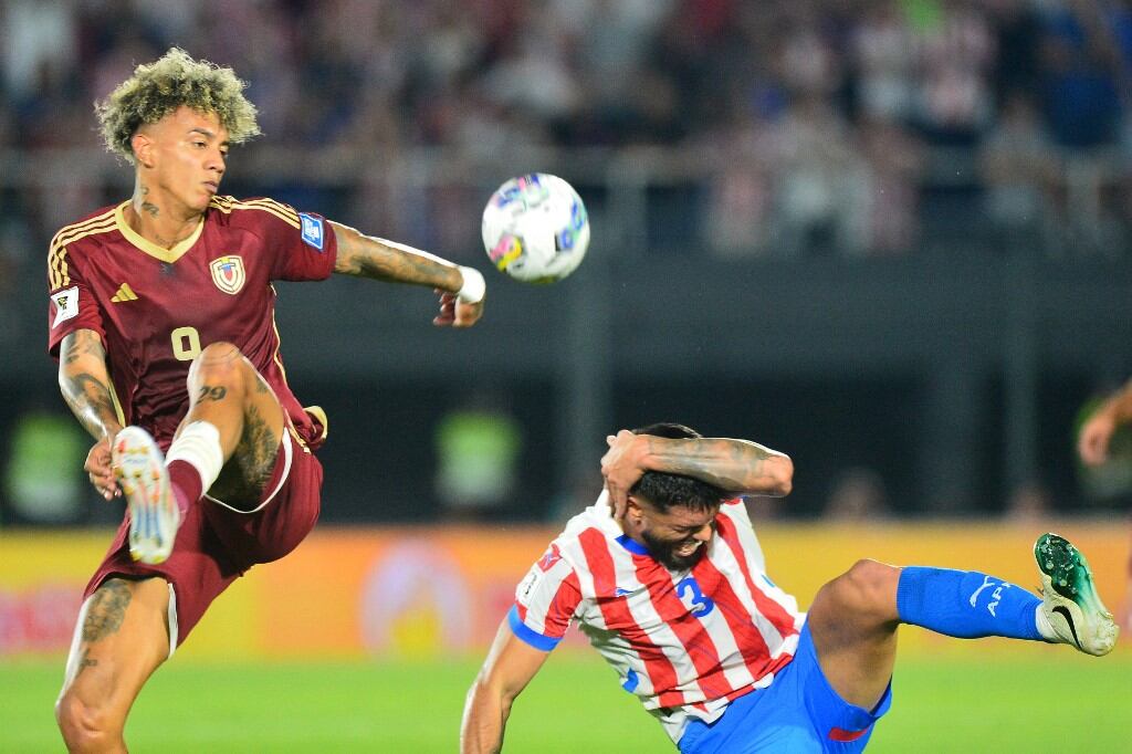 Venezuela's forward #09 Jhonder Cadiz and Paraguay's defender #03 Omar Alderete fight for the ball during the 2026 FIFA World Cup South American qualifiers football match between Paraguay and Venezuela at the Defensores del Chaco stadium in Asuncion on October 15, 2024. (Photo by Daniel Duarte / AFP)