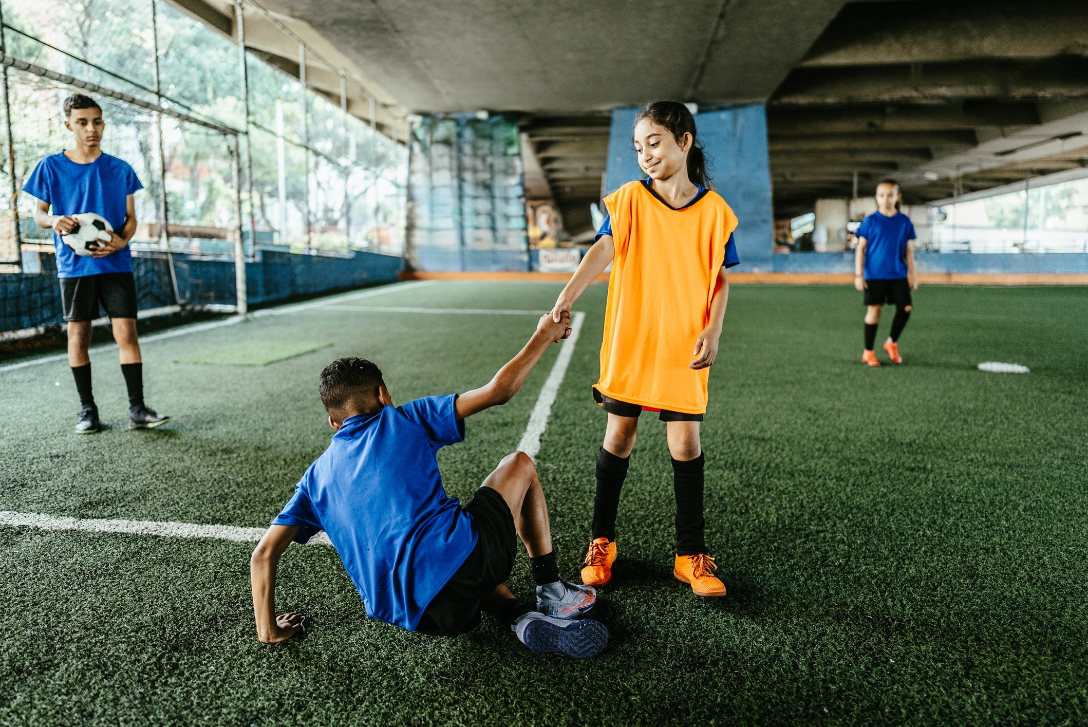 Niña ayuda a su compañero en pleno juego. Foto: Istock