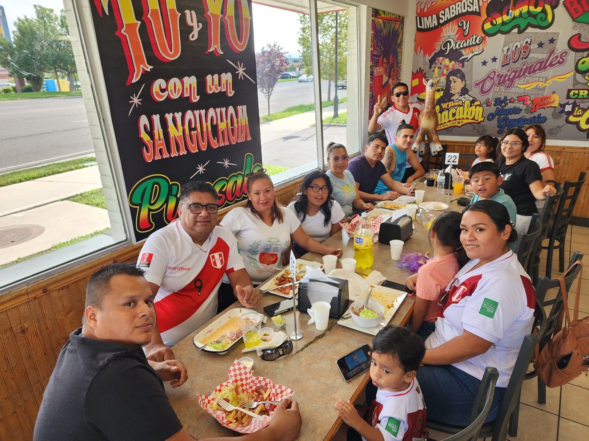 Lizandro Hinostroza, alias 'Chalo', junto a clientes peruanos en 'El rico Sanguchóm de Chalo'