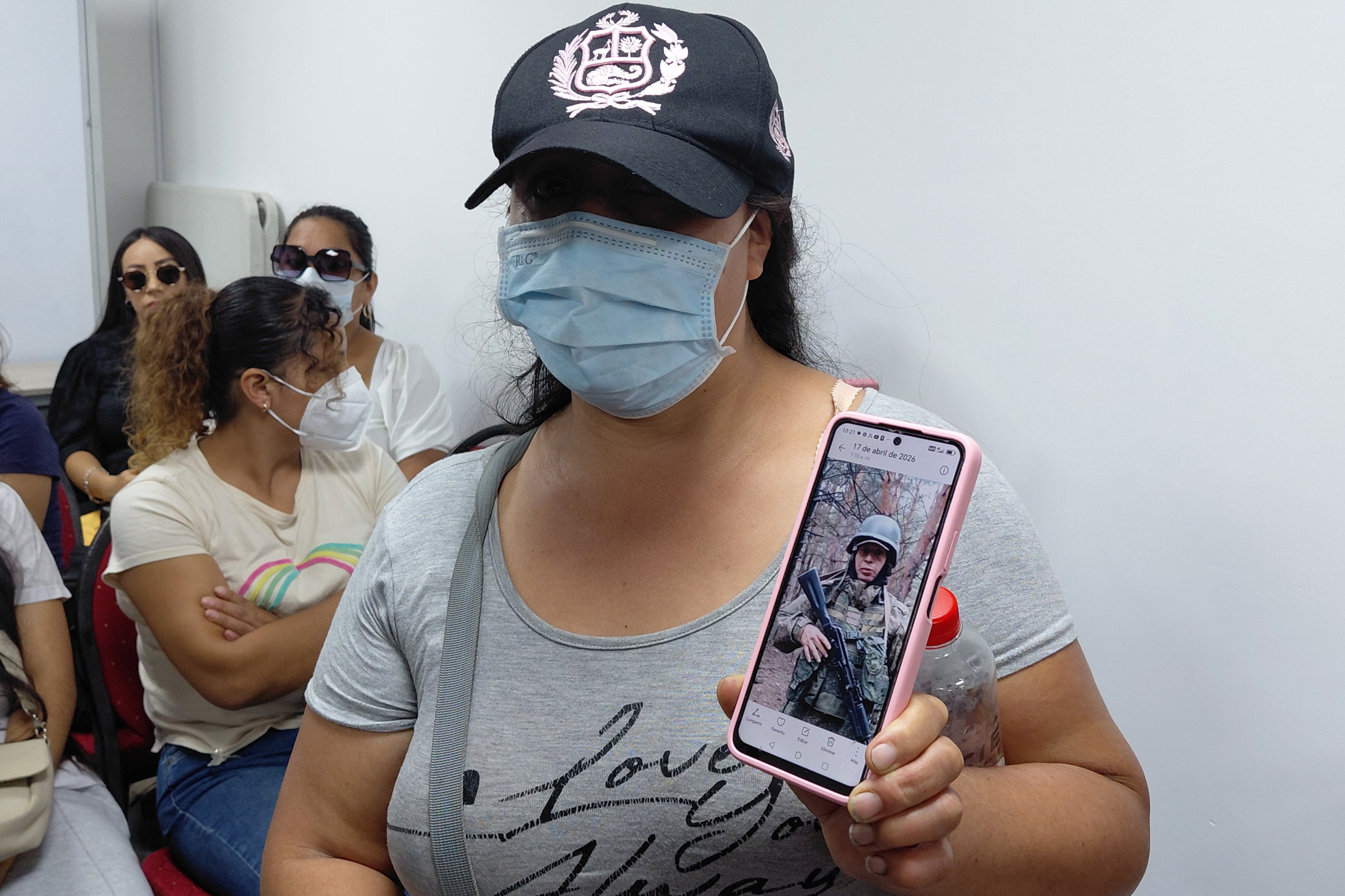 Una mujer muestra la fotografía de su esposo, un ciudadano peruano que está en la guerra en Ucrania. (EFE/ Paula Bayarte)