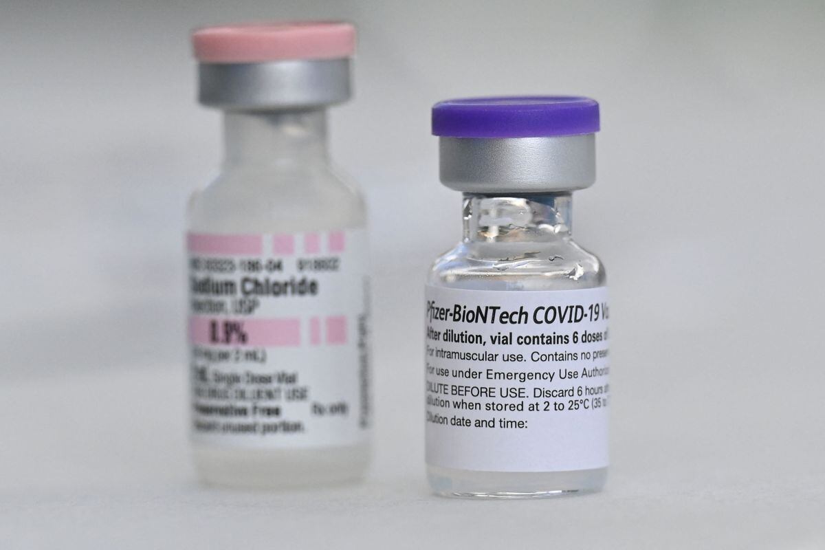 Los frascos de la vacuna Pfizer contra el COVID-19 y el cloruro de sodio (que se usa para diluir la vacuna) se ven en un evento de vacunación comunitaria en un vecindario predominantemente latino en Los Ángeles, California, el 11 de agosto de 2021 (Foto: Robyn Beck / AFP)