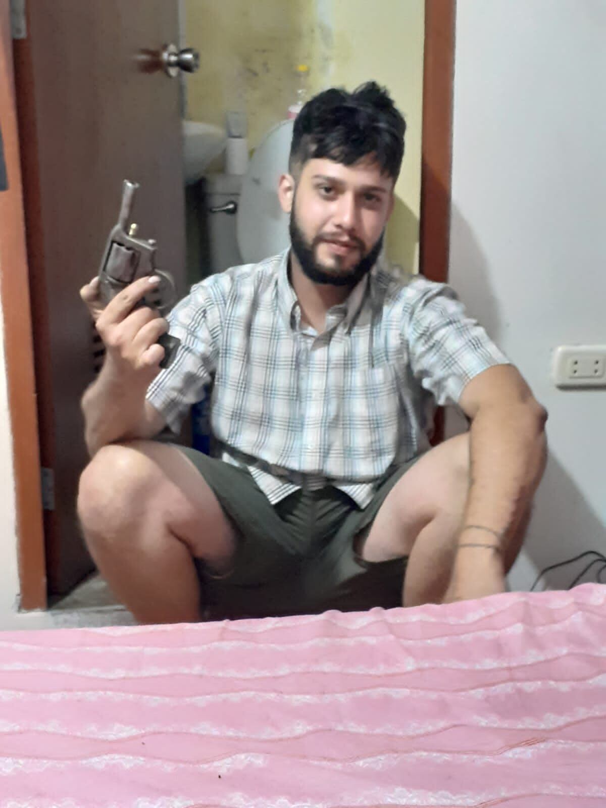 Expolicía Anthony Guzmán posando con revólver.