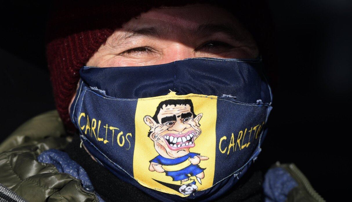 Un hombre con una máscara con la caricatura del delantero de Boca Juniors, Carlos Tevez, es visto en un punto de control en Buenos Aires. Imagen del 1 de julio de 2020. (AFP / Juan MABROMATA).