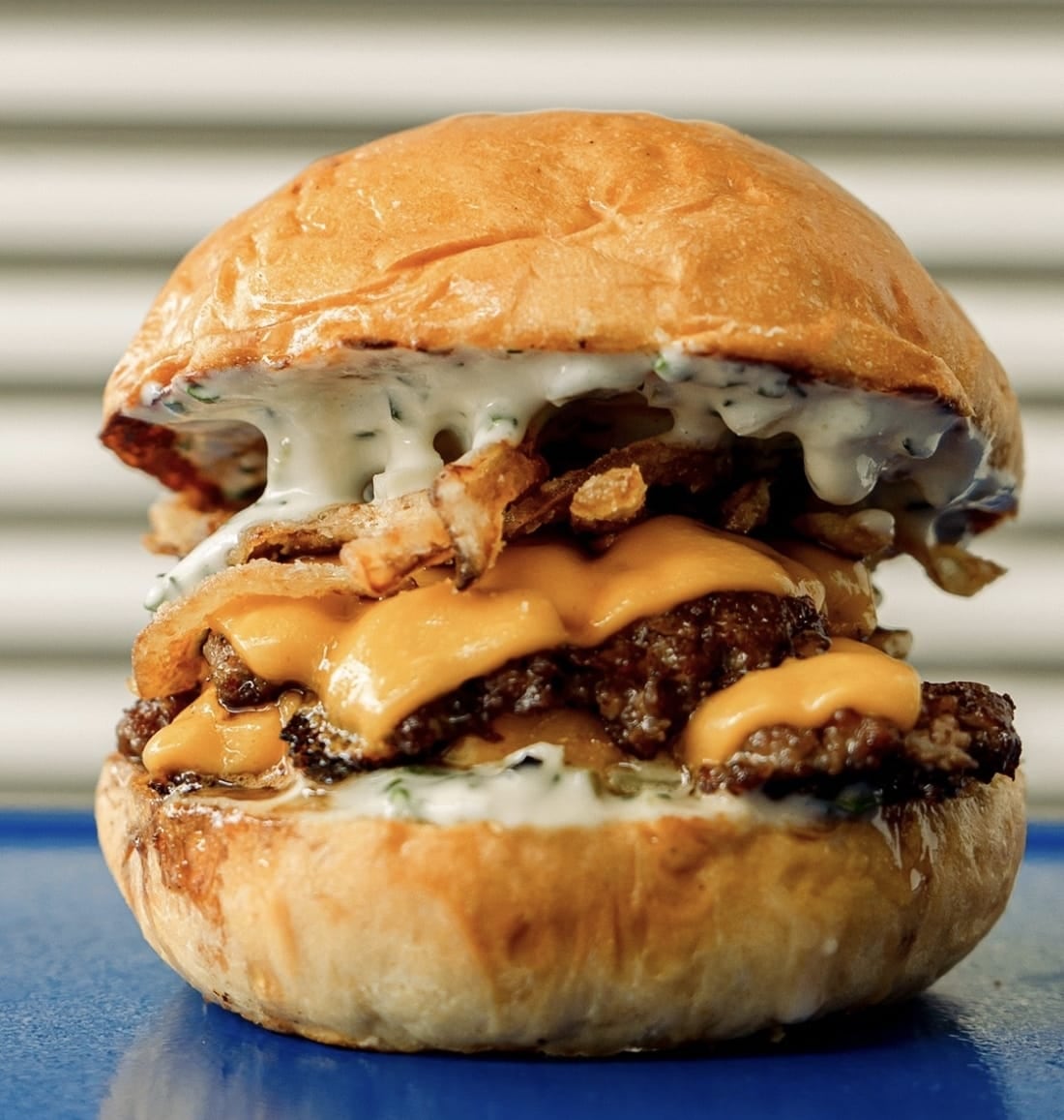 El Kauboi San es de doble carne, cebolla blanca, cheddar, salsa ranch jalapeño, teriyaki bbq