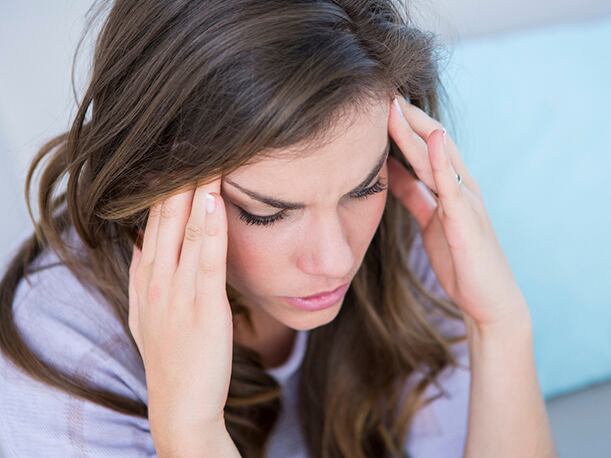 Mujer con dolor de cabeza, una de los efectos secundarios de la vacunación (Foto: IStock)