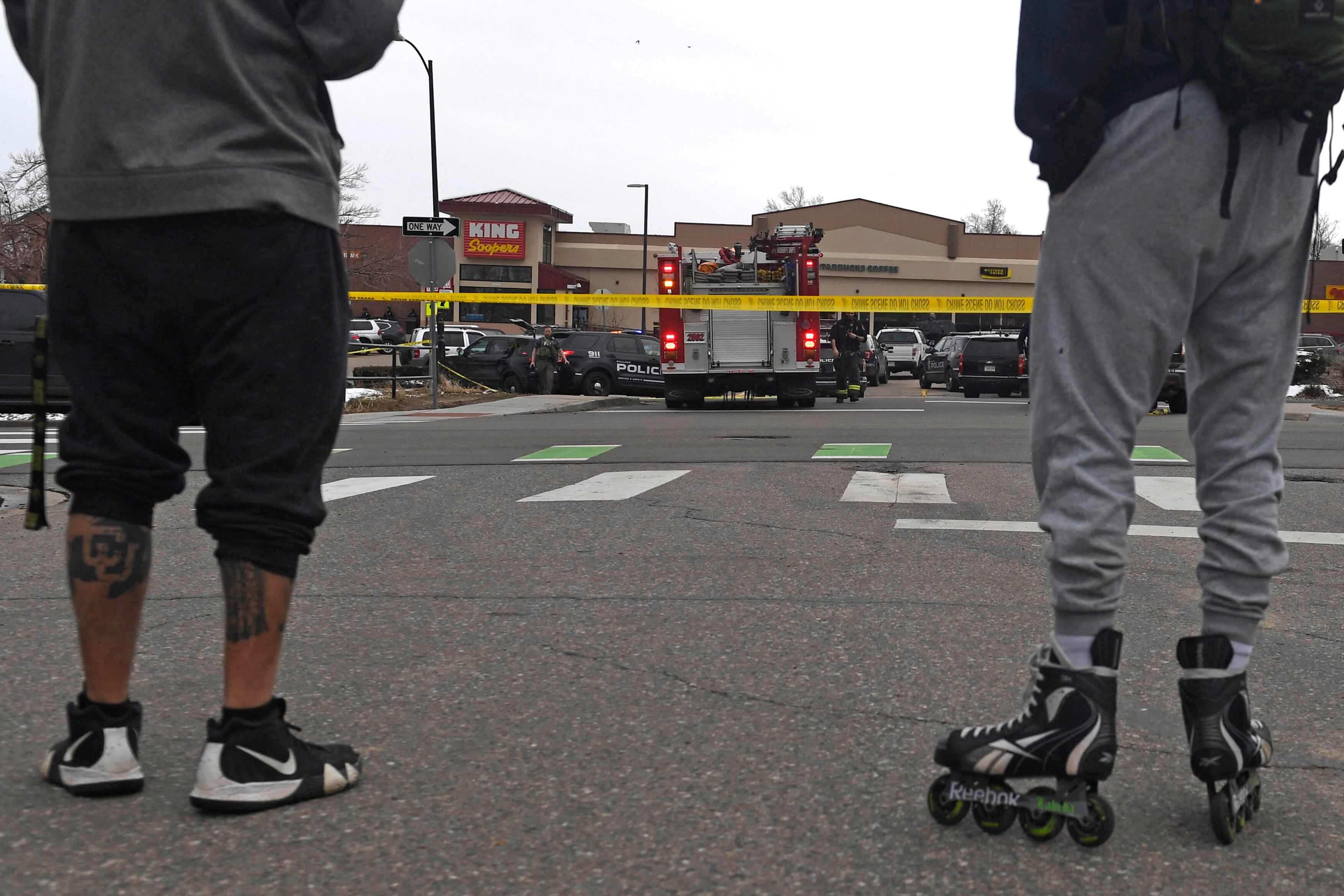 Los espectadores se paran afuera de la tienda de comestibles King Soopers en Boulder, Colorado, el 22 de marzo de 2021 después de los informes de un tirador activo. (Jason Connolly / AFP).