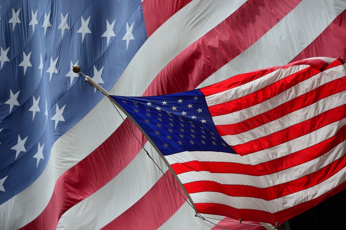Una bandera de Estados Unidos ondea frente a otra gran bandera en Nueva York. (Foto de Emmanuel DUNAND / AFP).