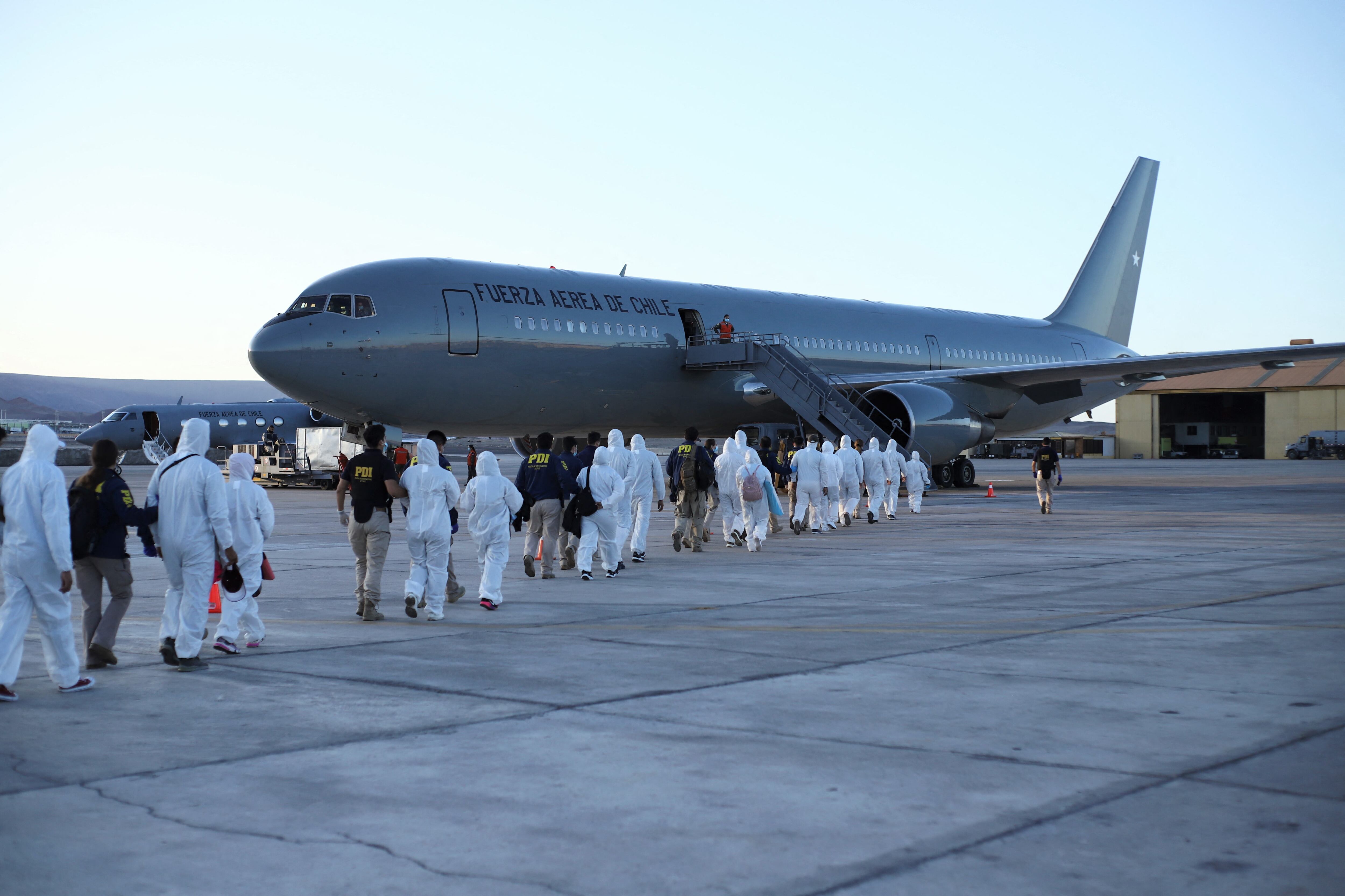 Migrantes venezolanos abordan un avión mientras son deportados luego de cruzar ilegalmente la frontera entre Bolivia y Chile, en el Aeropuerto Internacional General Diego Aracena Aguilar, en Iquique, Chile, el 10 de febrero de 2021. (Foto: IGNACIO MUNOZ / AFP)