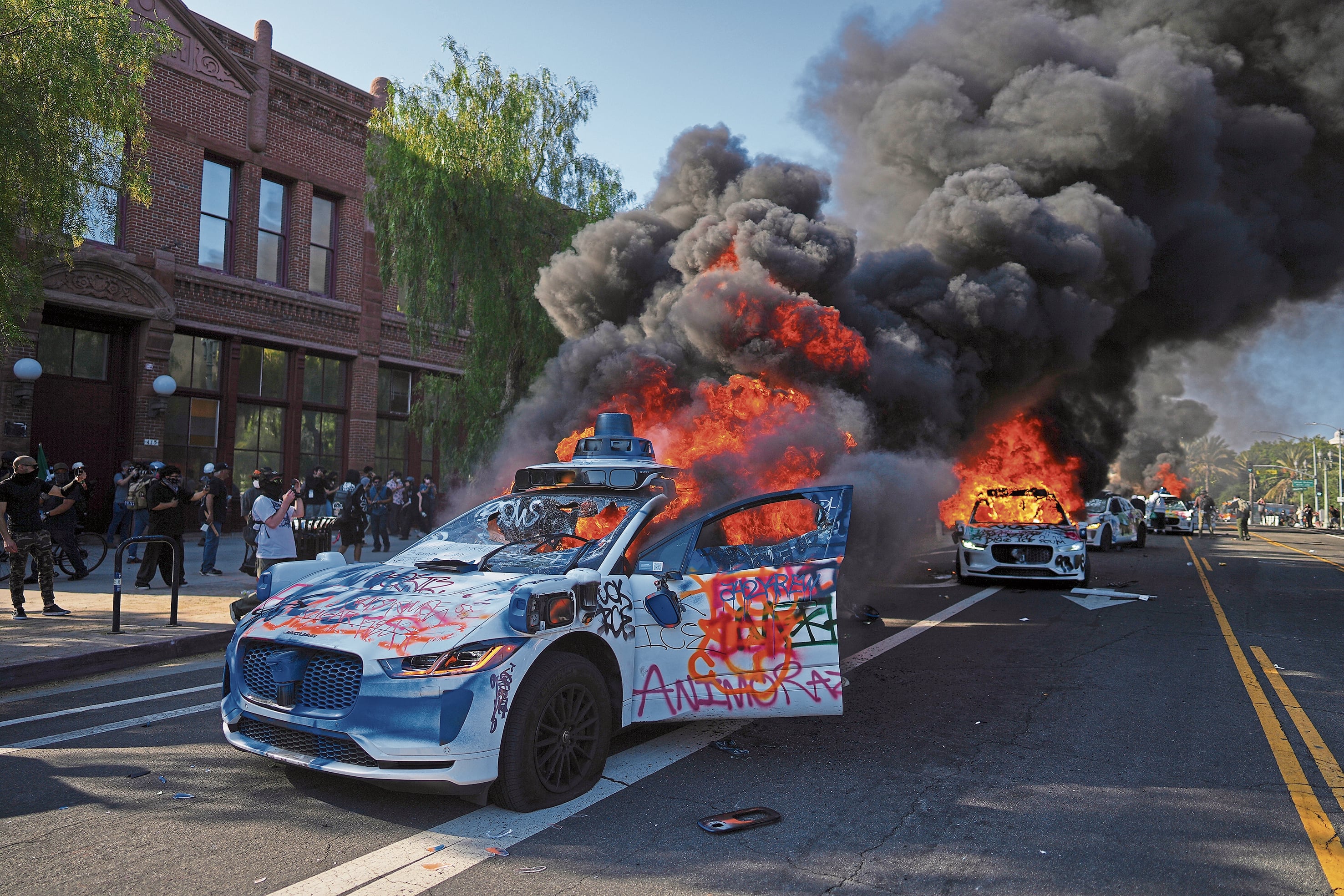 Multiple Waymo taxis burn near the Metropolitan Detention Center of downtown Los Angeles, Sunday, June 8, 2025, following last night's immigration raid protest. (AP Photo/Eric Thayer)
