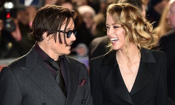 US actor Johnny Depp (L) jokes with fiancee US actress and model Amber Heard (R) as they arrive for the UK premiere of the film 'Mortdecai' in London on January 19, 2015. AFP PHOTO / LEON NEAL (Photo credit should read LEON NEAL/AFP/Getty Images)