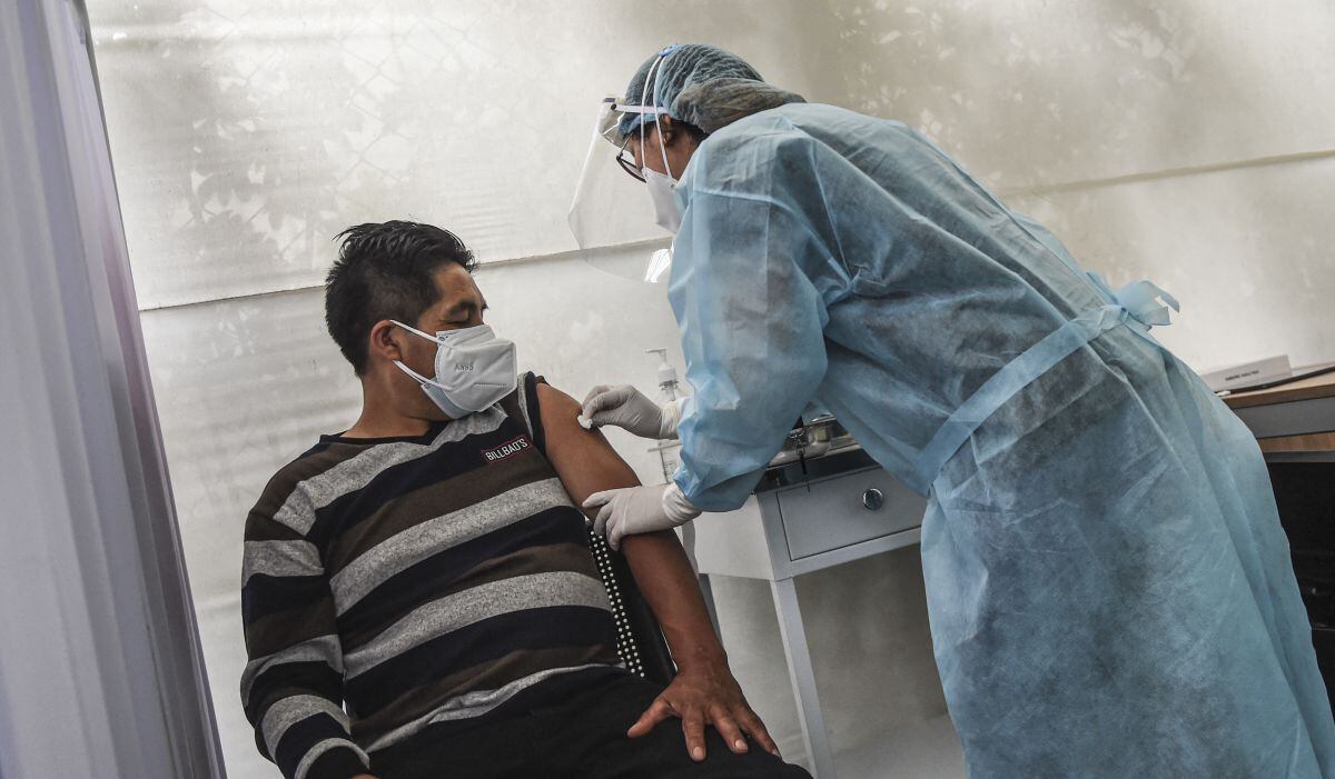 Un trabajador de salud prepara a un voluntario para recibir una vacuna COVID-19 producida por el chino Sinopharm durante su ensayo en el Centro de Estudios Clínicos de la Universidad Cayetano Heredia en Lima el 09 de diciembre de 2020. (Foto: AFP)