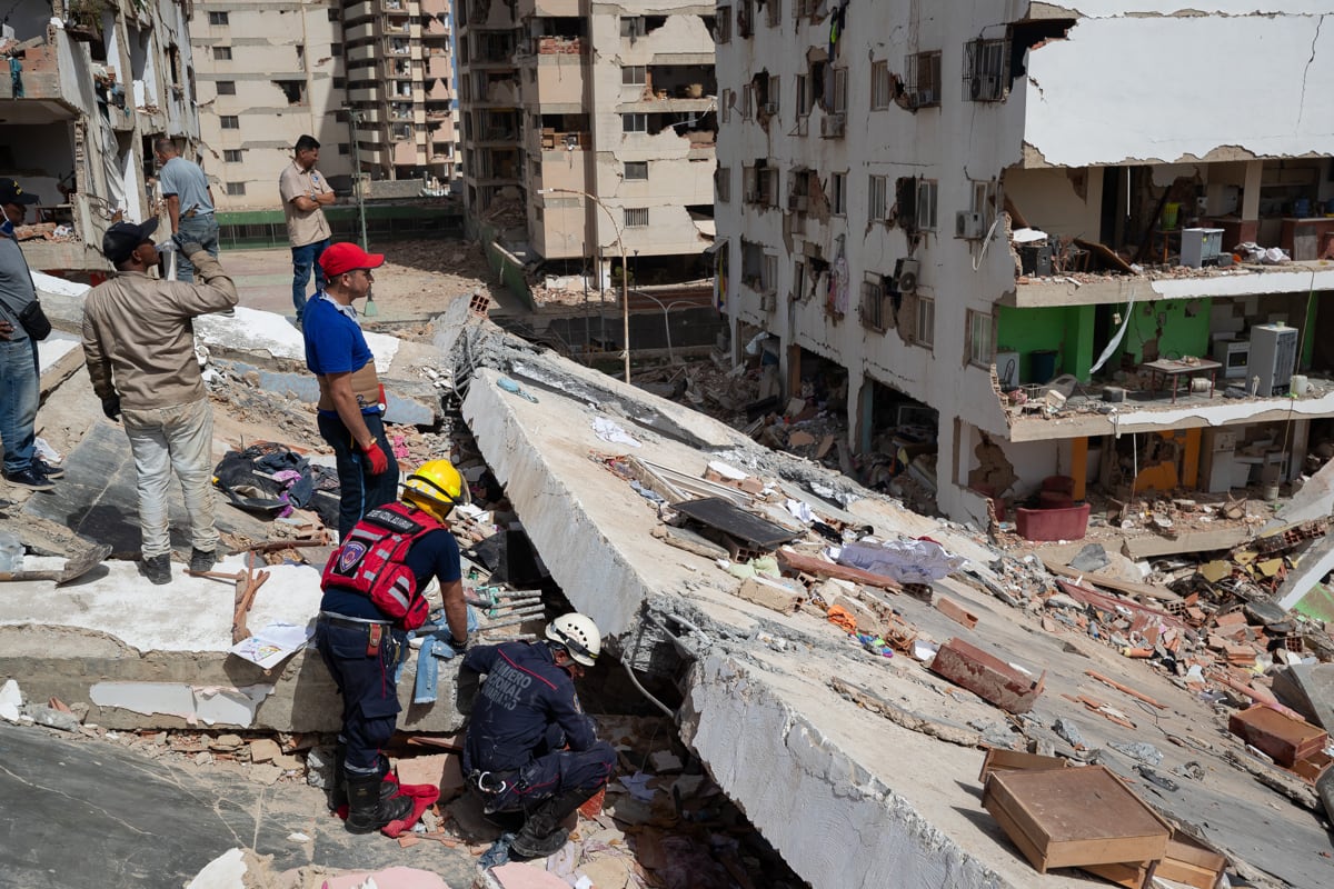 Personas realizan labores de búsqueda y remoción de escombros en edificios afectados por terremotos, en Catia La Mar, Venezuela, el 25 de junio de 2026. (Ronald Peña R / EFE)