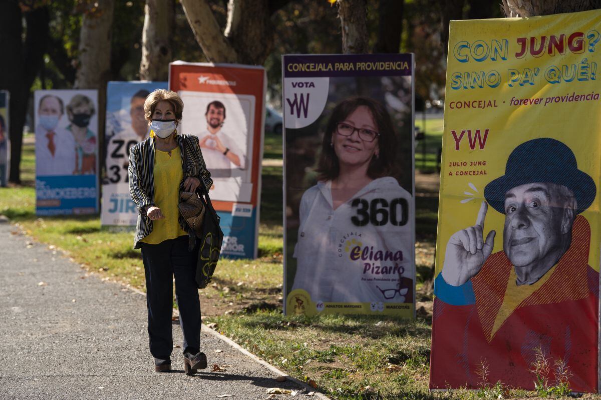 Una mujer pasa por delante de la propaganda electoral en Santiago (Chile), el 12 de mayo de 2021. (MARTIN BERNETTI / AFP).