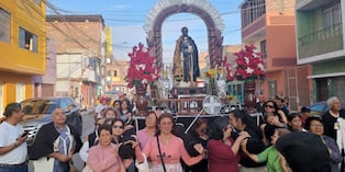 Fieles llevan las andas de San Martín de Porres en procesión.