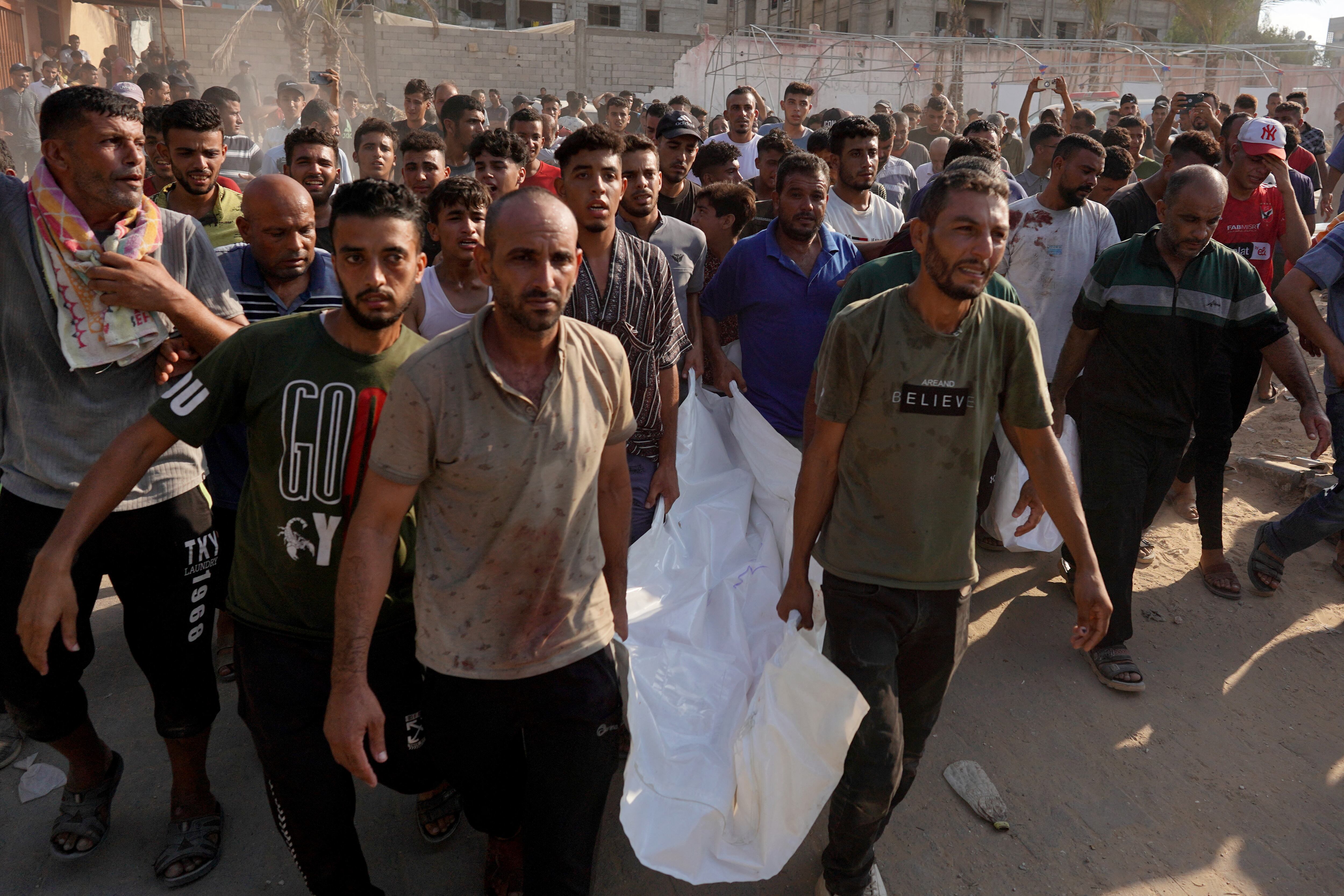 Hombres palestinos transportan los cuerpos de dos víctimas del hospital Nasser para enterrarlos, después de que las fuerzas israelíes atacaran el distrito nororiental de Khan Yunis, en el sur de la Franja de Gaza, el 24 de julio de 2024, en medio del conflicto en curso entre Israel. (Foto de Bashar TALEB / AFP)