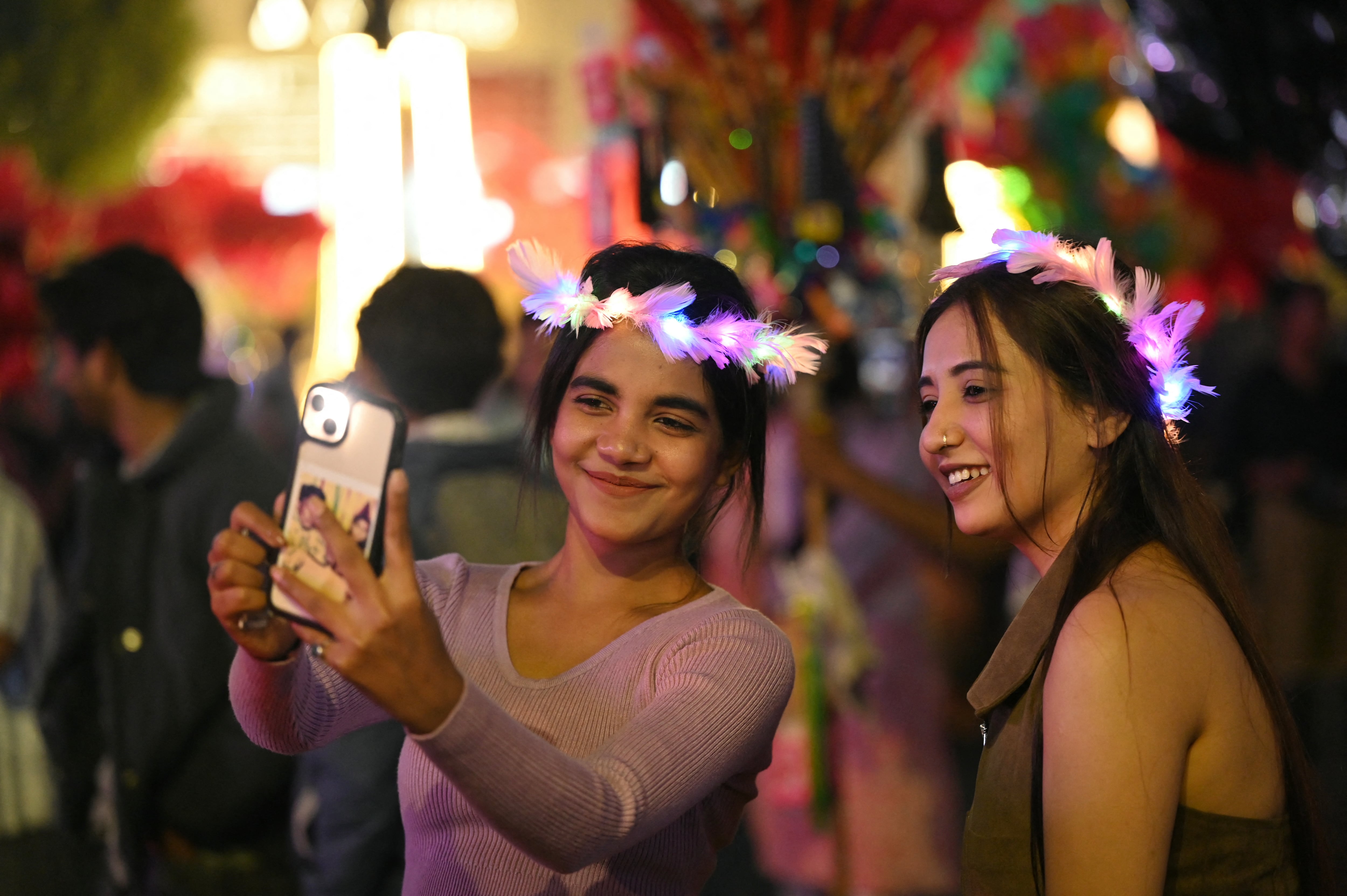 Los asistentes celebran el Año Nuevo en la calle CG de Ahmedabad, India, el 31 de diciembre de 2025. (Foto de Shammi MEHRA / AFP).