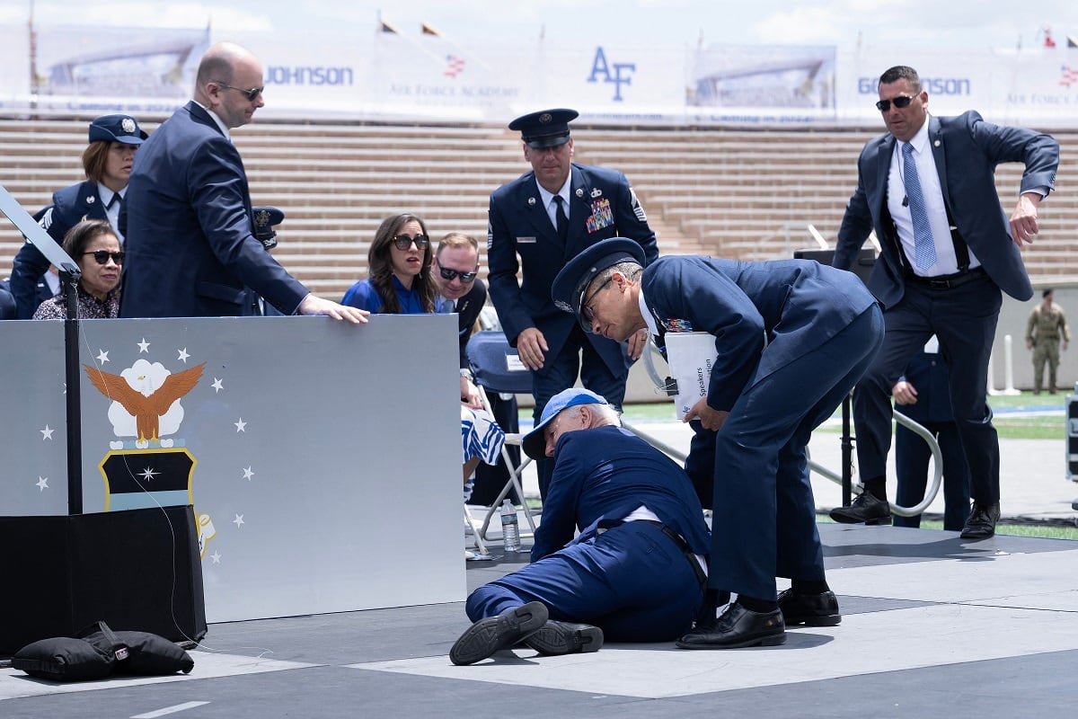 El presidente de los Estados Unidos, Joe Biden, recibe ayuda tras caerse durante la ceremonia de graduación en la Academia de la Fuerza Aérea de los Estados Unidos (Foto de Brendan Smialowski / AFP)