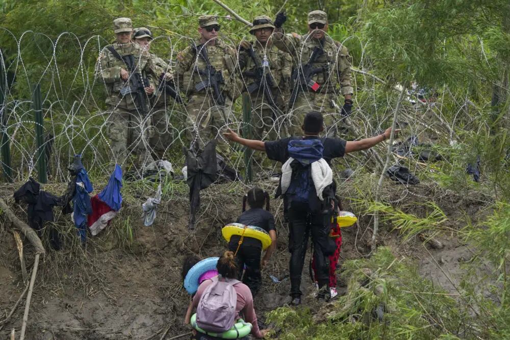 Migrantes con niños y adultos cruzan el Río Bravo con la esperanza de llegar a suelo estadounidense. (AP).