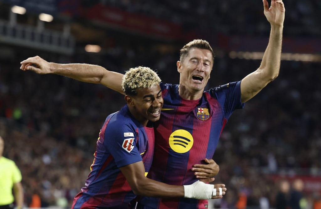 Barcelona's Polish forward #09 Robert Lewandowski (R) celebrates with Barcelona's Spanish forward #10 Lamine Yamal scoring his team's second goal during the Spanish league football match between FC Barcelona and Real Sociedad at the Estadi Olimpic Lluis Companys in Barcelona on September 28, 2025. (Photo by Josep LAGO / AFP)