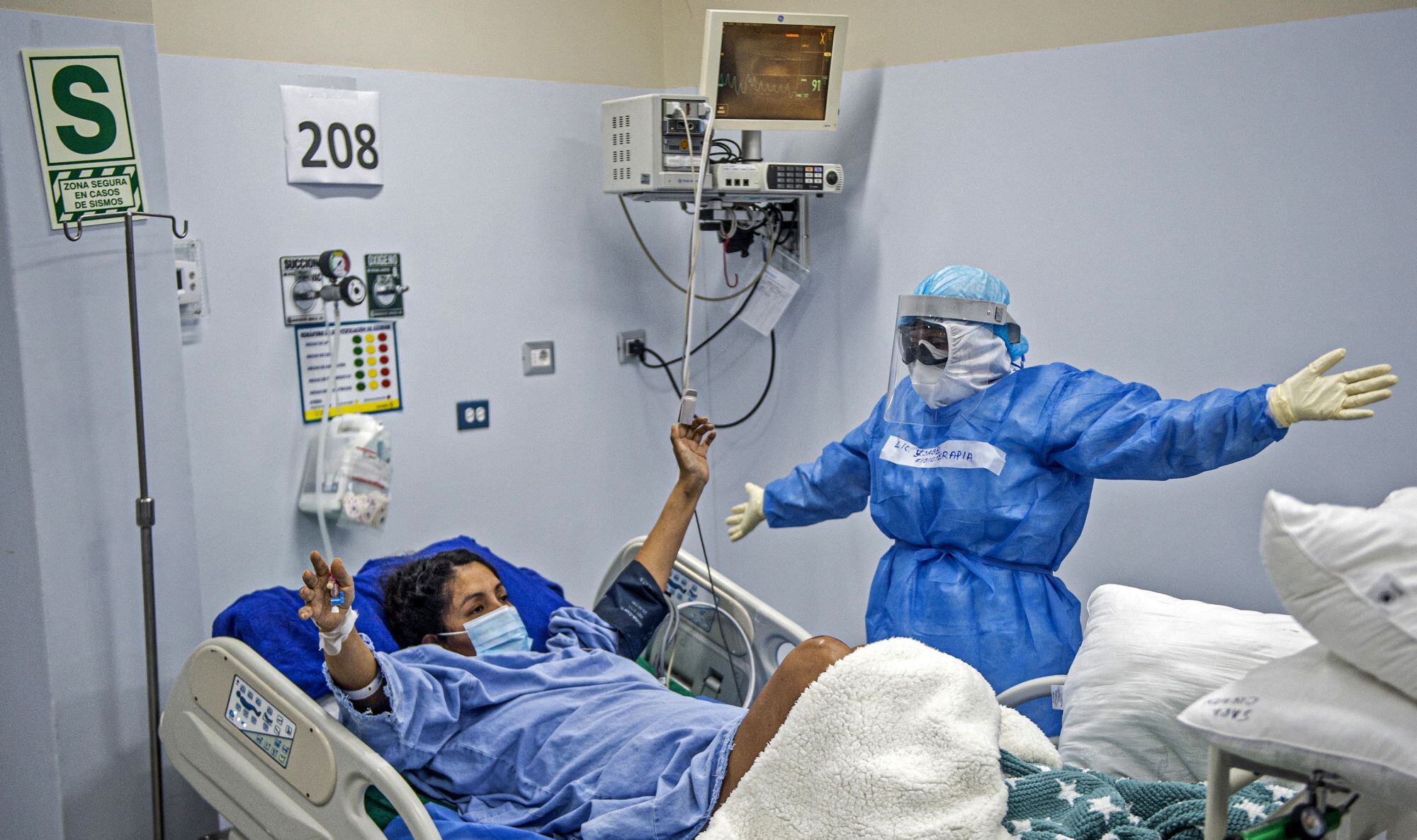 Una enfermera realiza fisioterapia en un paciente con coronavirus COVID-19 en la Unidad de Cuidados Intensivos del Hospital Alberto Sabogal Sologuren, en Lima, Perú. (Foto por Ernesto BENAVIDES / AFP).