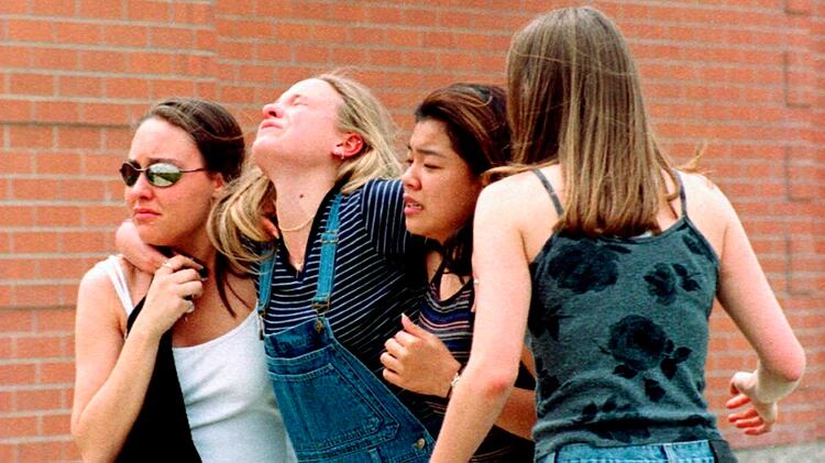 Una mujer se abraza junta a alumnas de la escuela de Columbine, cerca la biblioteca, pocos después de la masacre del 20 de abril de 1999. (Foto: AP)