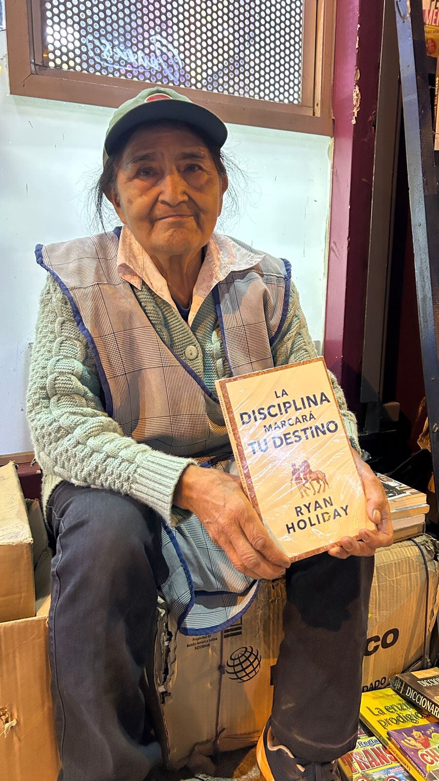 María Nila Torres Villa con uno de los libros que vende.