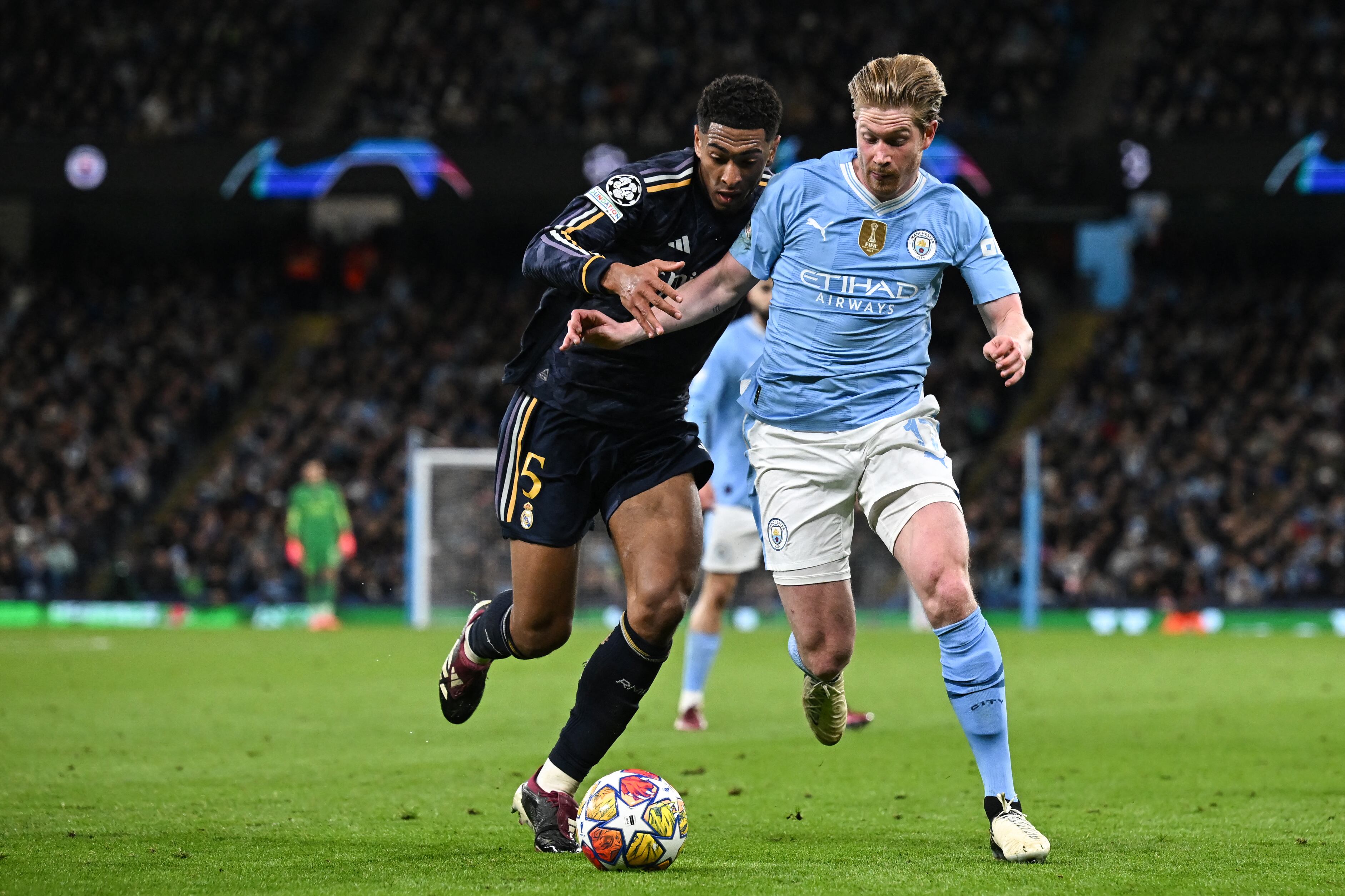 Real Madrid's English midfielder #5 Jude Bellingham (L) fights for the ball with Manchester City's Belgian midfielder #17 Kevin De Bruyne during the UEFA Champions League quarter-final second-leg football match between Manchester City and Real Madrid, at the Etihad Stadium, in Manchester, north-west England, on April 17, 2024. (Photo by Paul ELLIS / AFP)