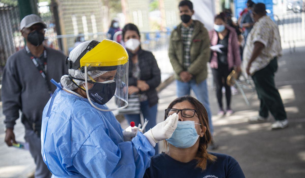 Una mujer se hace la prueba de COVID-19 en un centro de salud ubicado en la calle en Lima el 11 de enero de 2022 (Foto: Ernesto BENAVIDES / AFP)