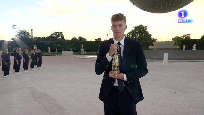 Léon Marchand, con na pequeña linterna, carga el fuego olímpico de París 2024 (@RTVE)