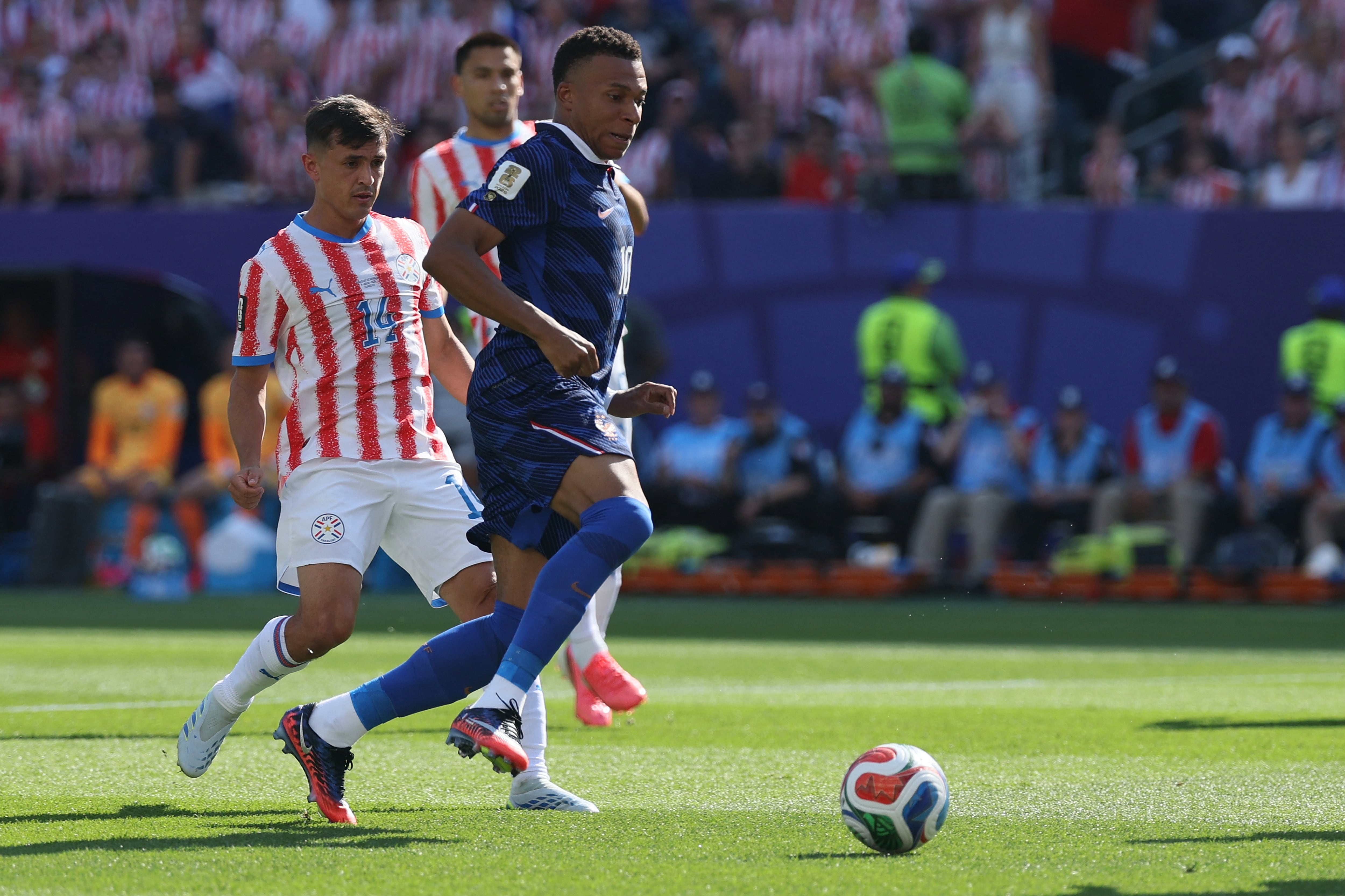 France's forward #10 Kylian Mbappe (R) runs with the ball past Paraguay's midfielder #14 Andres Cubas during the 2026 World Cup round of 16 football match between Paraguay and France at the Philadelphia Stadium in Philadelphia on July 4, 2026. (Photo by Odd ANDERSEN / AFP)