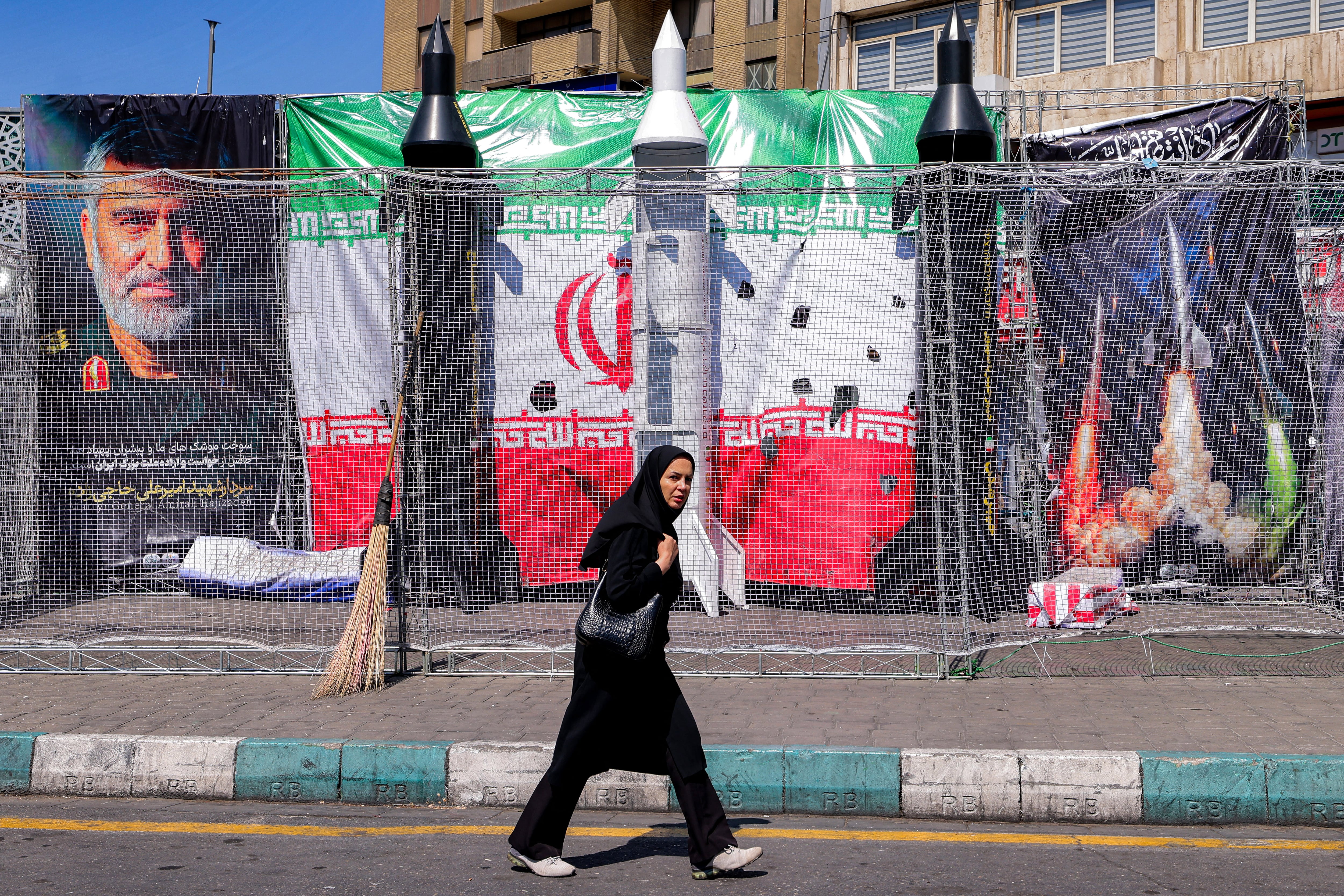 Una mujer camina junto a maquetas de misiles iraníes en la plaza Valiasr de Teherán, Irán, el 6 de abril de 2026. (Foto de ATTA KENARE / AFP).