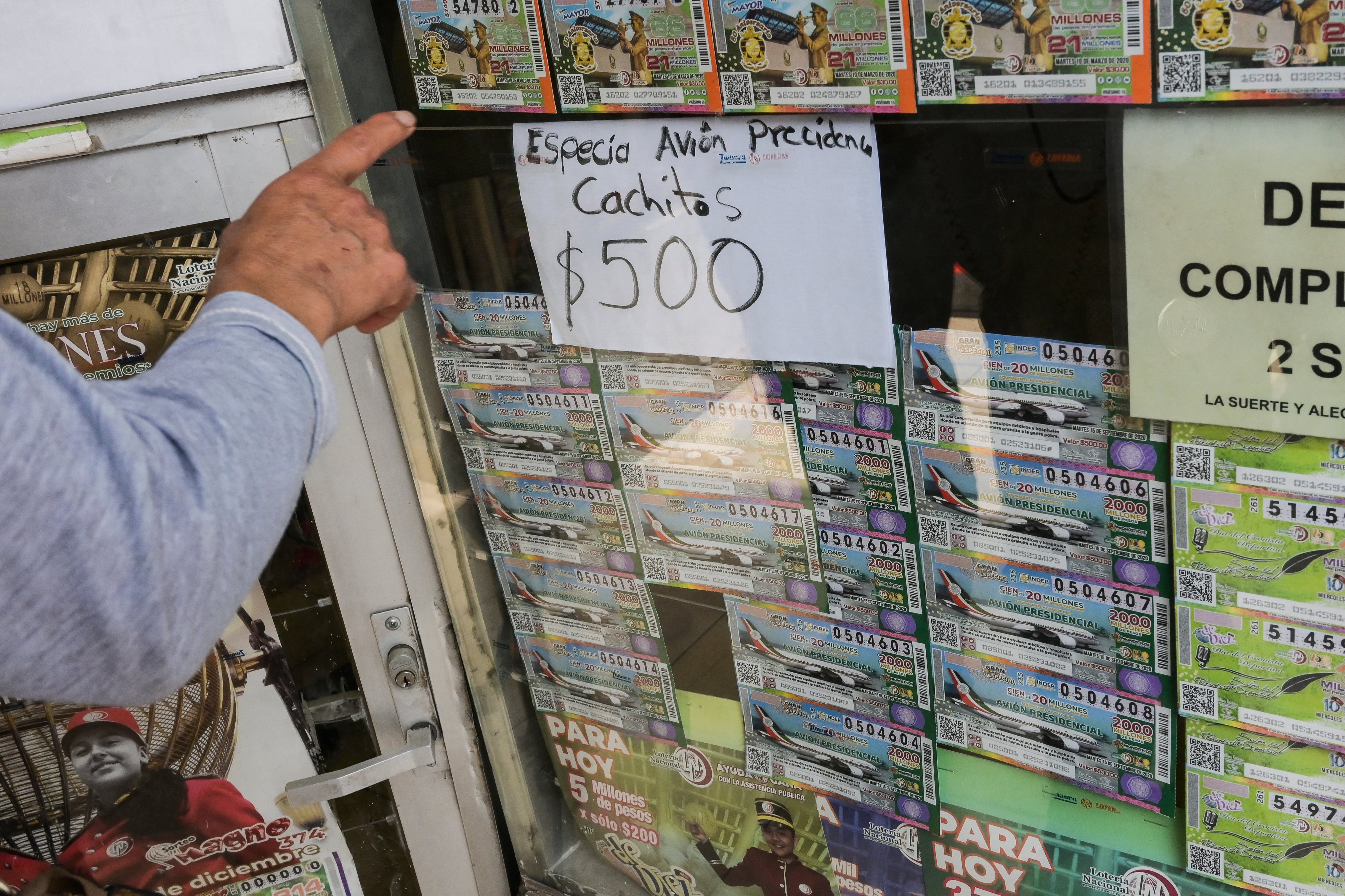 Un hombre mira boletos de lotería que representan el lujoso avión presidencial en la Ciudad de México, el 10 de marzo de 2020. - El gobierno de la Ciudad de México comenzó a vender boletos de lotería para participar en el sorteo de aviones del presidente el próximo 15 de septiembre de 2020. (Foto de Pedro PARDO / AFP)