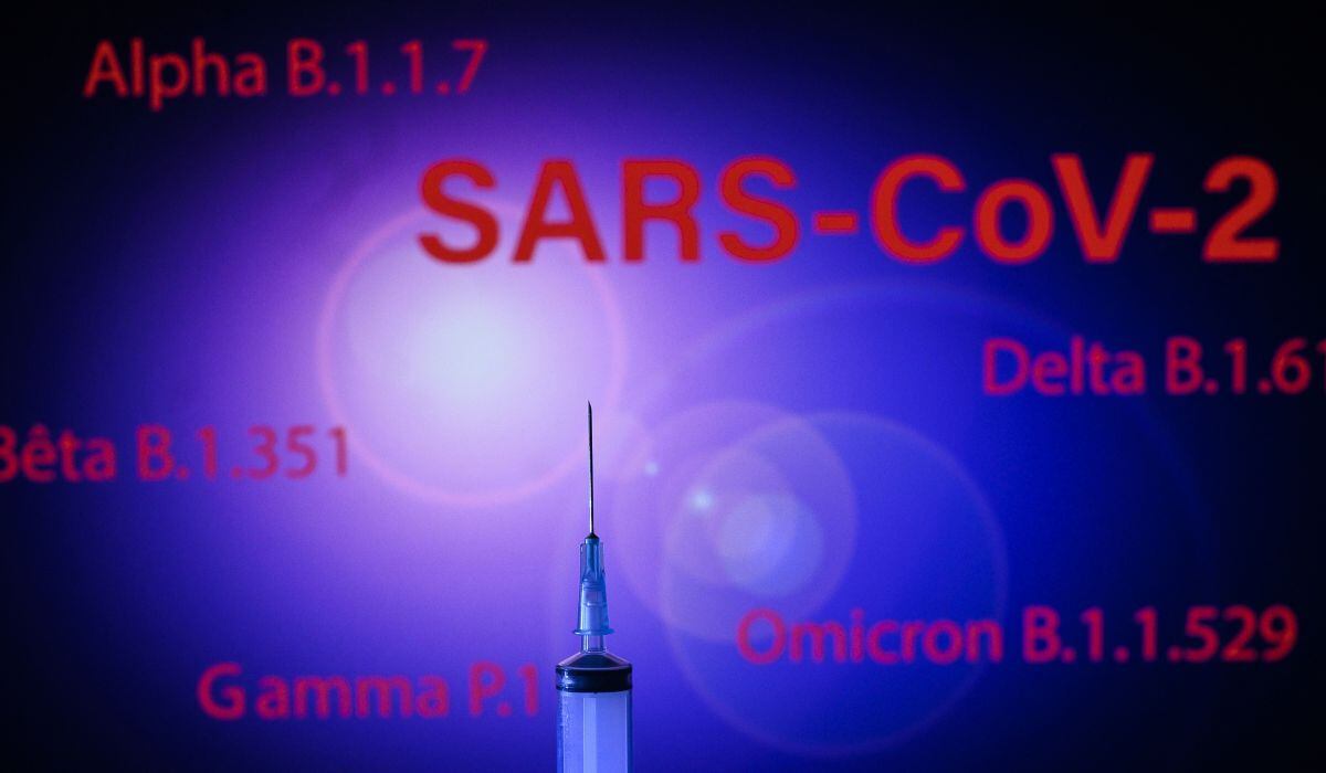 Esta fotografía tomada el 2 de diciembre de 2021 muestra una jeringa y una pantalla que muestra las variantes principales del SARS-Cov-2: Alpha, Beta, Delta, Gamma y Omicron, en Toulouse (Foto: Lionel Bonaventure / AFP)