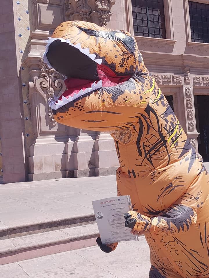 Joven llama la atención de las redes sociales por vestirse de dinosaurio para recoger su título universitario. (Facebook: Abel Monsivais Badillo)