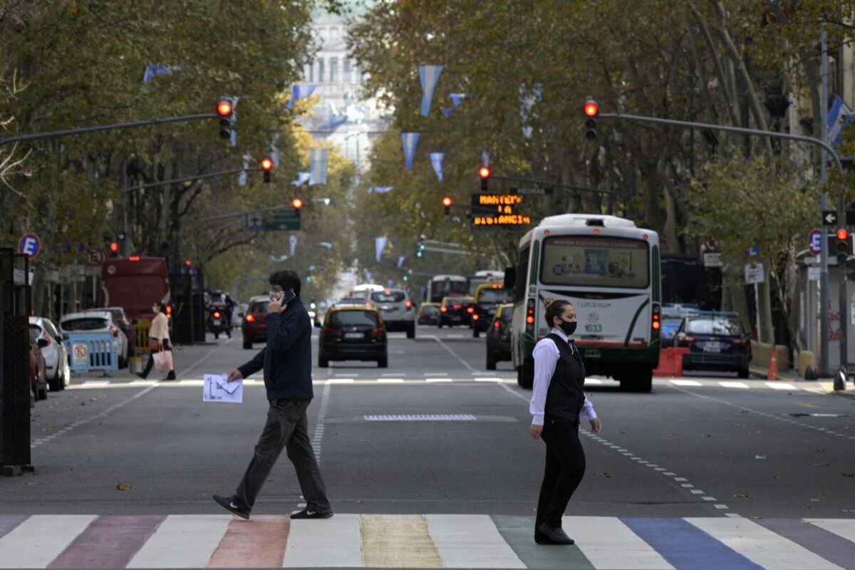 La gente cruza la Avenida de Mayo en Buenos Aires, el 28 de mayo de 2021, en medio de la pandemia de coronavirus. (Foto de JUAN MABROMATA / AFP).
