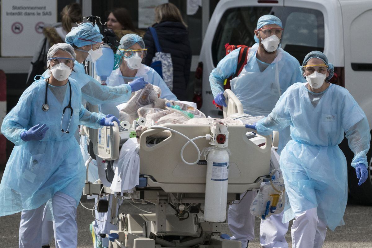 El personal médico lleva a un paciente de coronavirus hacia un helicóptero en el Hospital Emile Muller en Mulhouse, este de Francia. (Foto de SEBASTIEN BOZON / AFP).