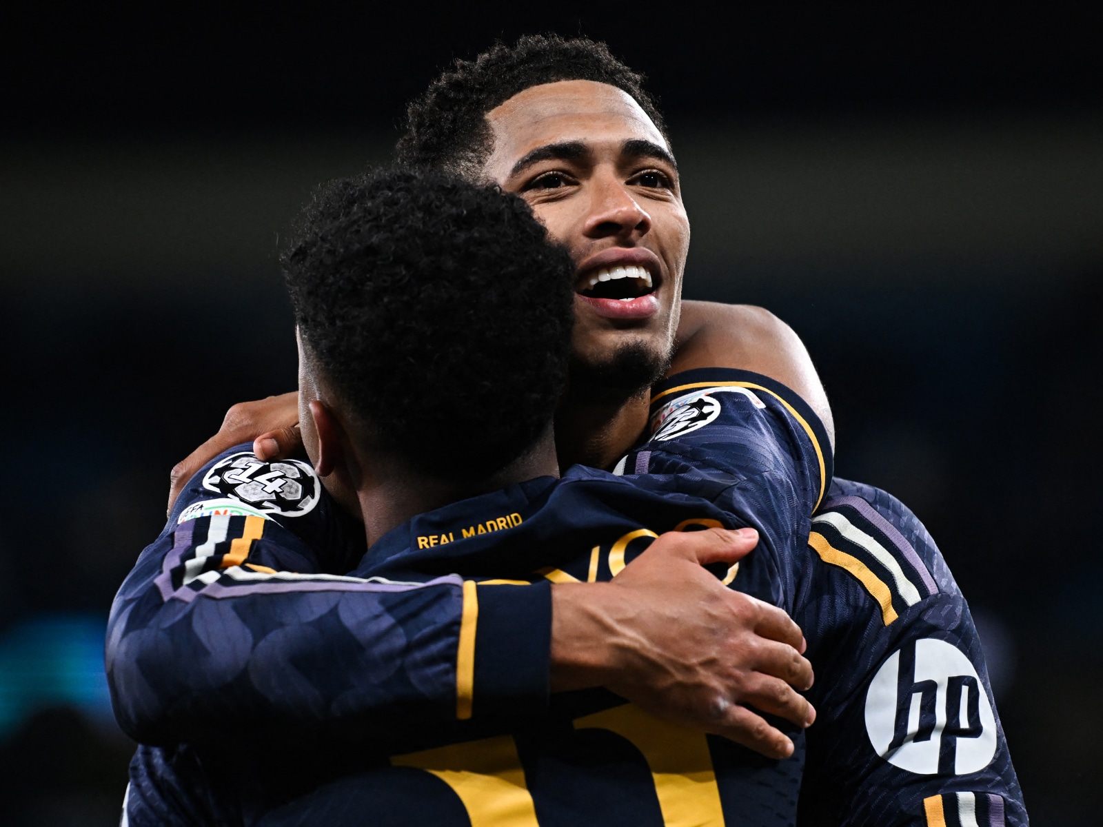 El centrocampista inglés del Real Madrid #5 Jude Bellingham (detrás) y el delantero brasileño del Real Madrid #11 Rodrygo celebran tras ganar en el partido de fútbol de vuelta en Champions League.