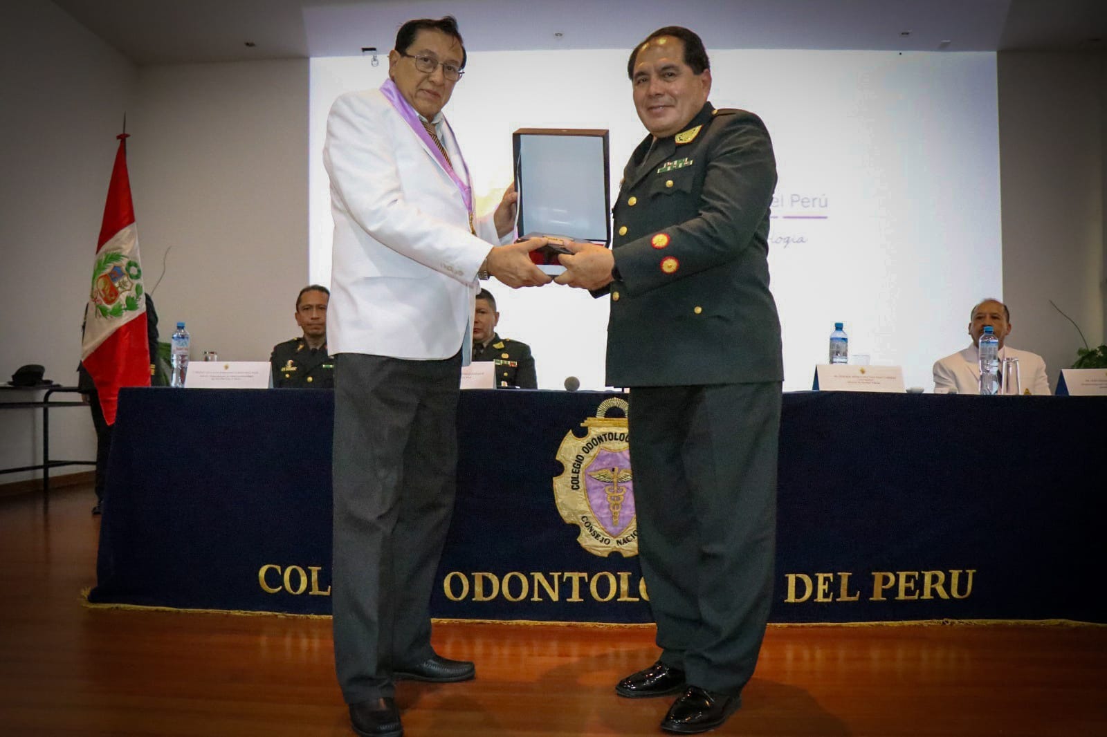 Decano del Colegio Odontológico del Perú, Dr. Luis Ghezzi Hernández, entrega reconocimiento al director de la Dirección de Sanidad Policial (Dirsapol), general médico PNP Nagy Cabrera Contreras