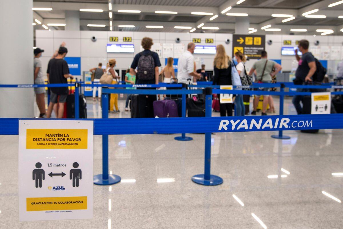Tourists wait to check in for a flight at the Ryan Air counter at the airport in Palma de Mallorca on July 27, 2020. - Tour operator TUI has cancelled all British holidays to mainland Spain from today until August 9, after the UK government's decision to require travellers returning from the country to quarantine. (Photo by JAIME REINA / AFP)