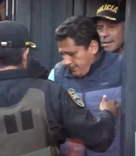 Hombre de chaleco que acompañó a Chibolín en su traslado al penal