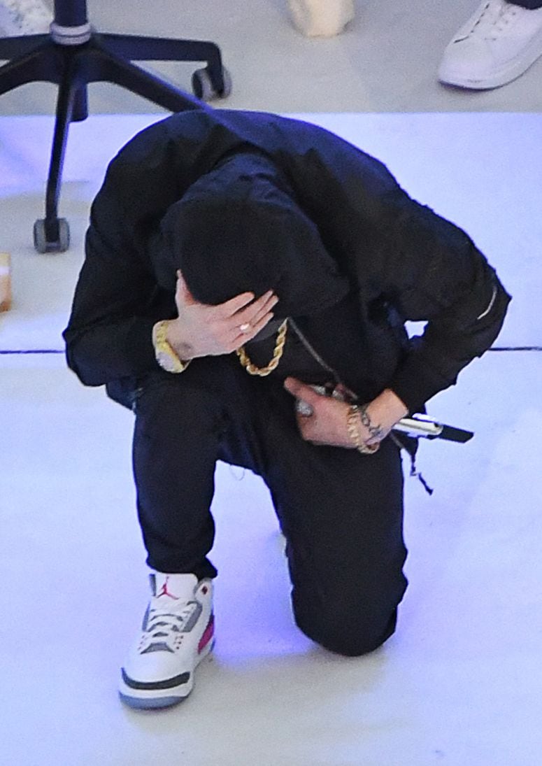 US rapper Eminem kneels on stage during the halftime show of Super Bowl LVI between the Los Angeles Rams and the Cincinnati Bengals at SoFi Stadium in Inglewood, California, on February 13, 2022. (Photo by VALERIE MACON / AFP)