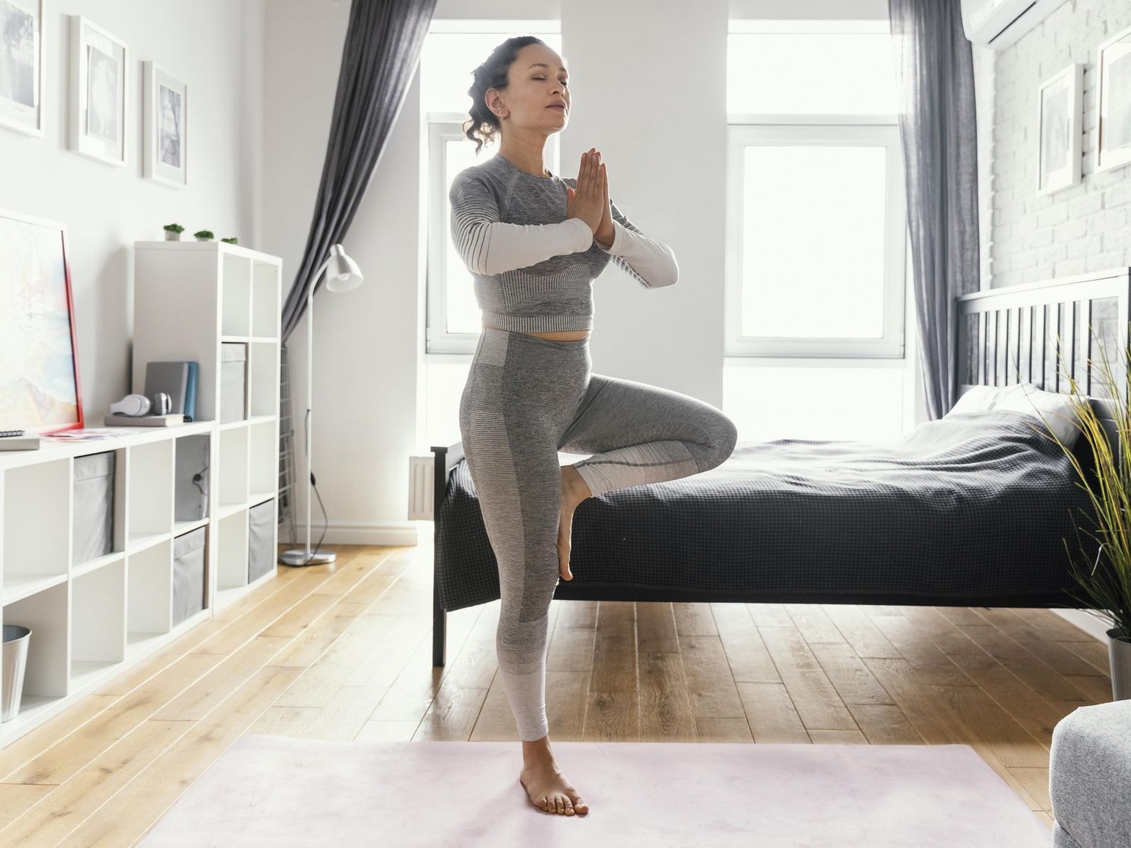 En esta imagen se aprecia a una mujer muy concentrada mientras realiza un ejercicio en casa. Foto: Freepik