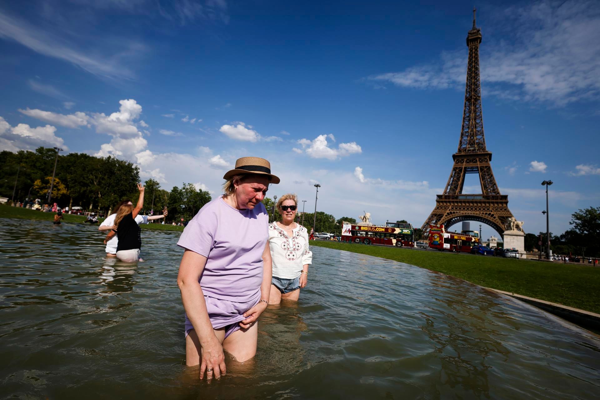 Varias personas se refrescan en la Fuente del Trocadero, junto a la Torre Eiffel, en París, Francia. (EFE/EPA/YOAN VALAT).