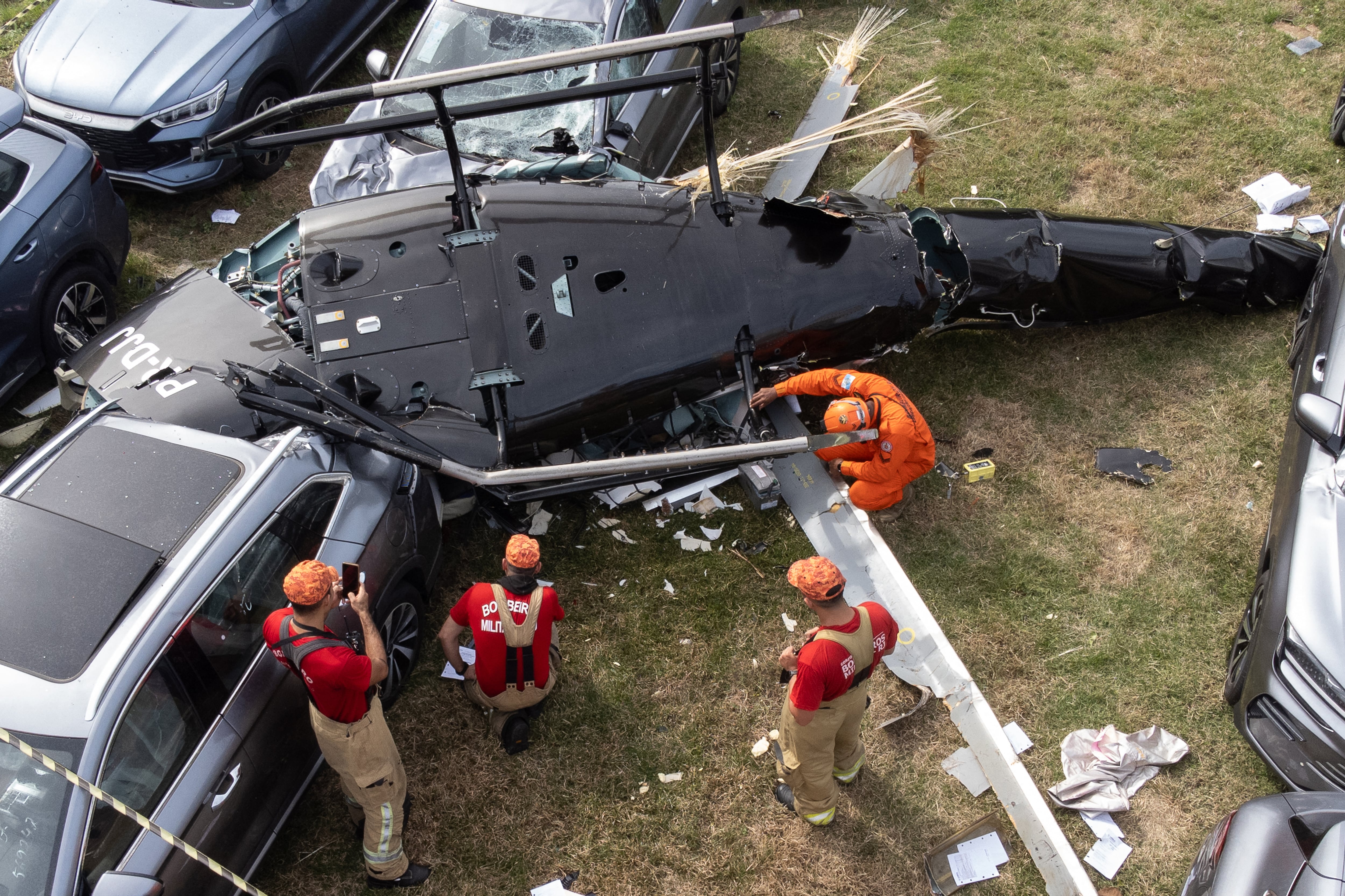 Una vista aérea muestra a los bomberos trabajando en el lugar del accidente de un helicóptero en el barrio Recreio dos Bandeirantes de Río de Janeiro, Brasil, el 14 de junio de 2026. (Foto de Tercio TEIXEIRA / AFP).