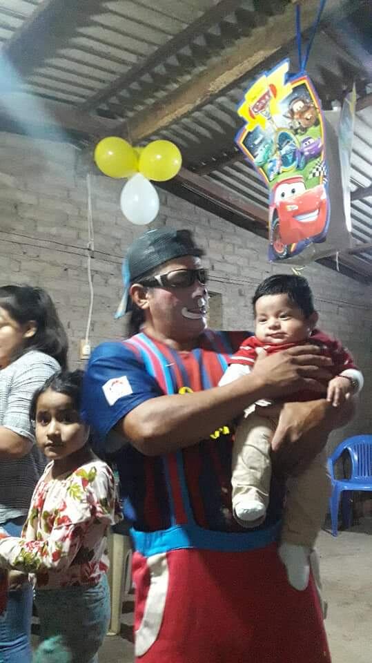 Gino cargando en sus brazos a Alexander, de nueve meses, el más pequeño de sus hijos.