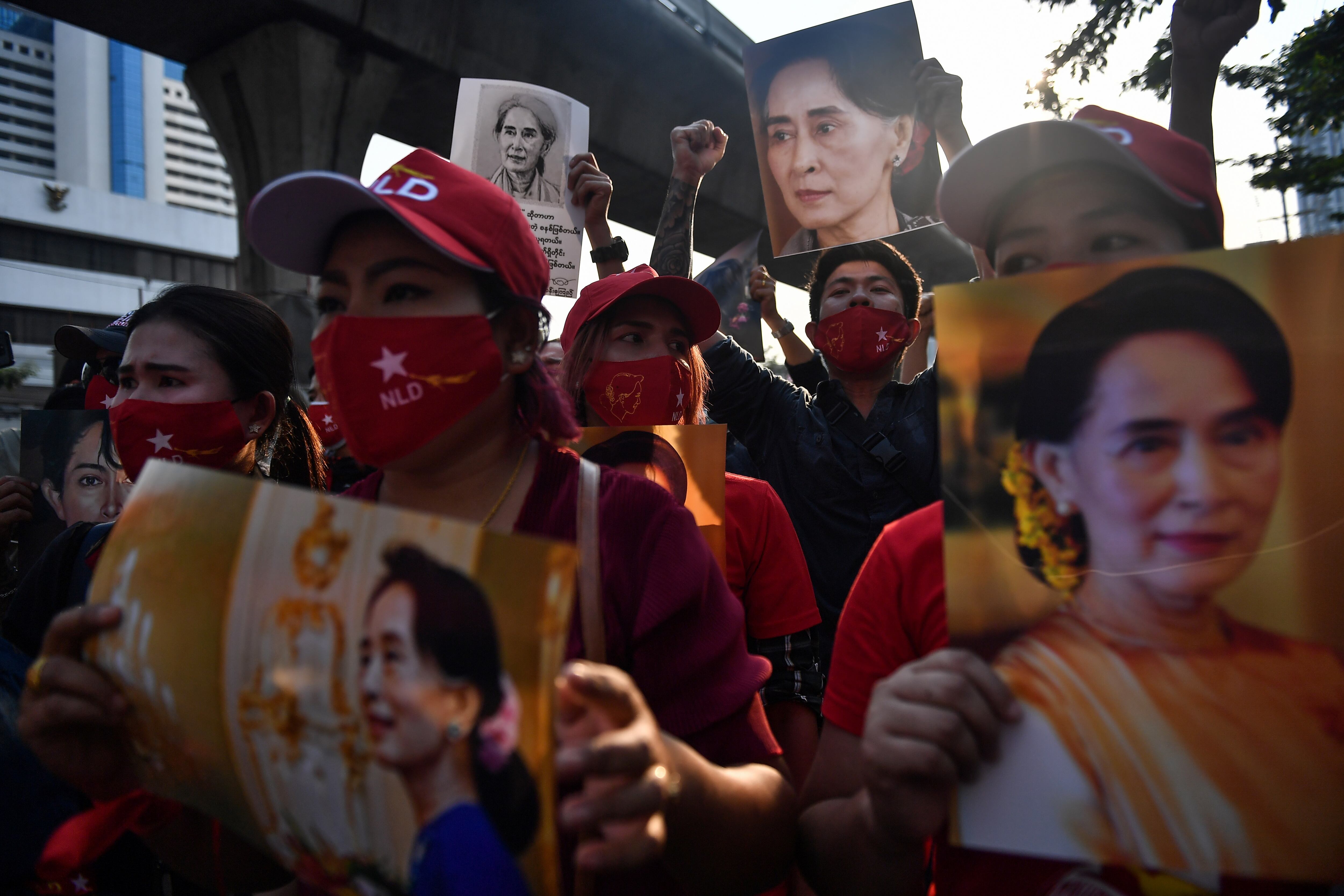 Migrantes en Birmania protestan hoy sosteniendo imágenes de la líder política Aung San Suu Kyi frente a la embajada del país en Bangkok, tras el golpe militar. (Foto: AFP)