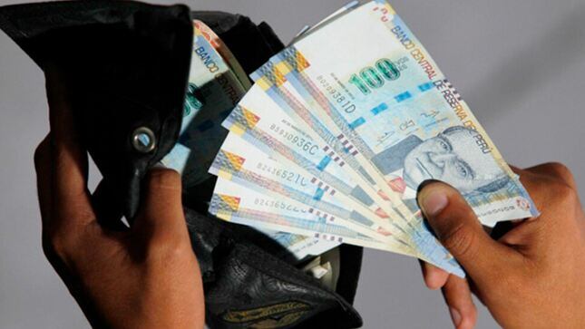 Un ciudadano guardando sus billetes de cien soles (Foto: Gobierno del Perú)