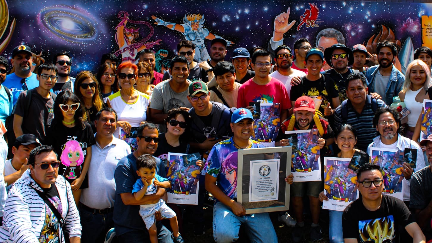 Jorge de Pegaso posa junto a fans, frente al mural que ha preparado en la pared de su vivienda.