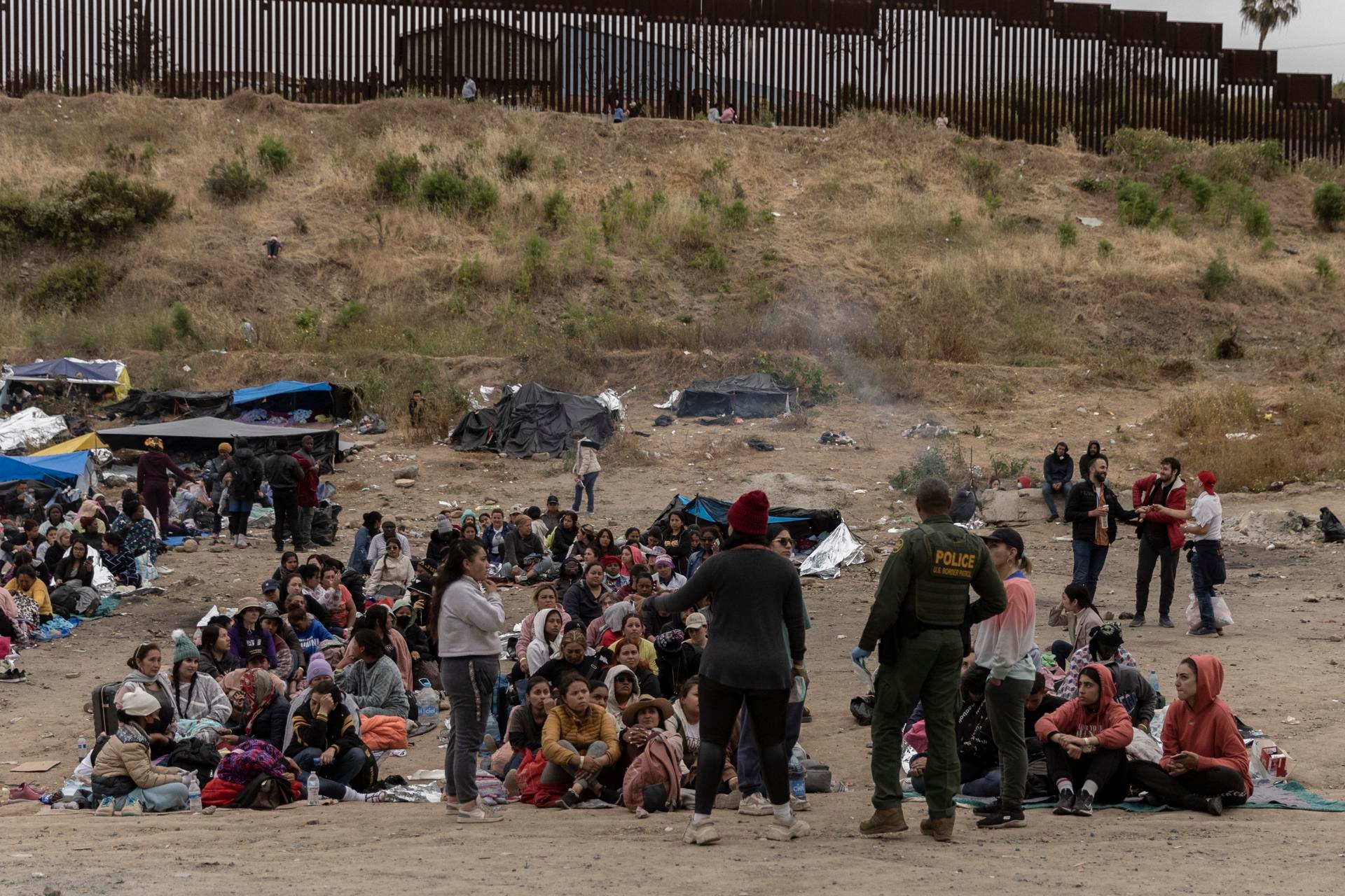Migrantes reunidos en la tierra de nadie entre EE. UU. y México, en San Diego, California EFE/EPA/ETIENNE LAURENT